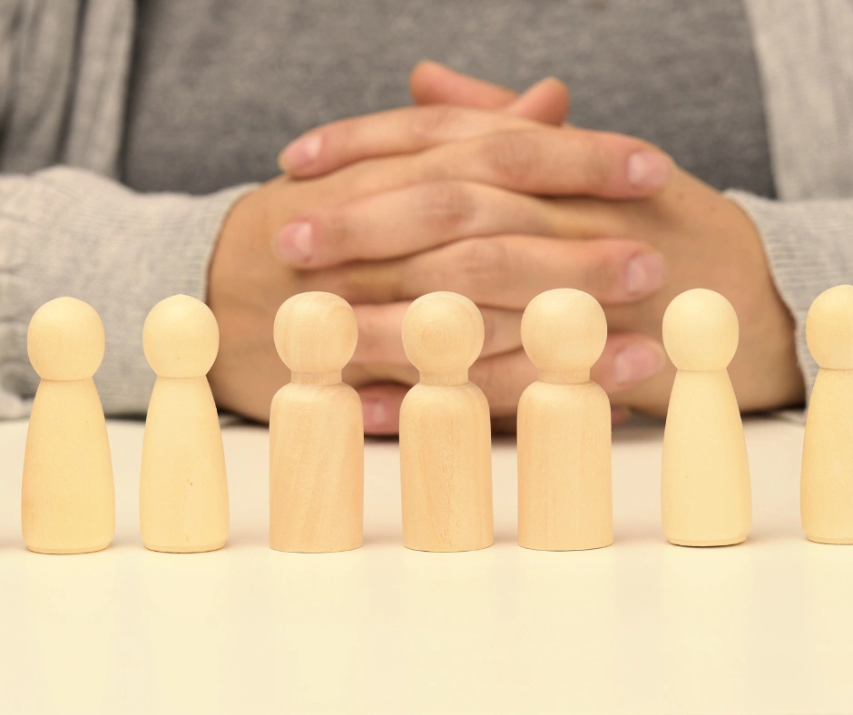 Houten poppetjes staan opgesteld tijdens kindertherapie in begeleidingsruimte van Maduh