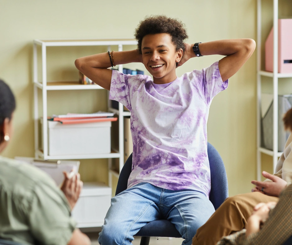 Jongere blij in sessie met begeleiding in therapieruimte van Praktijk Maduh