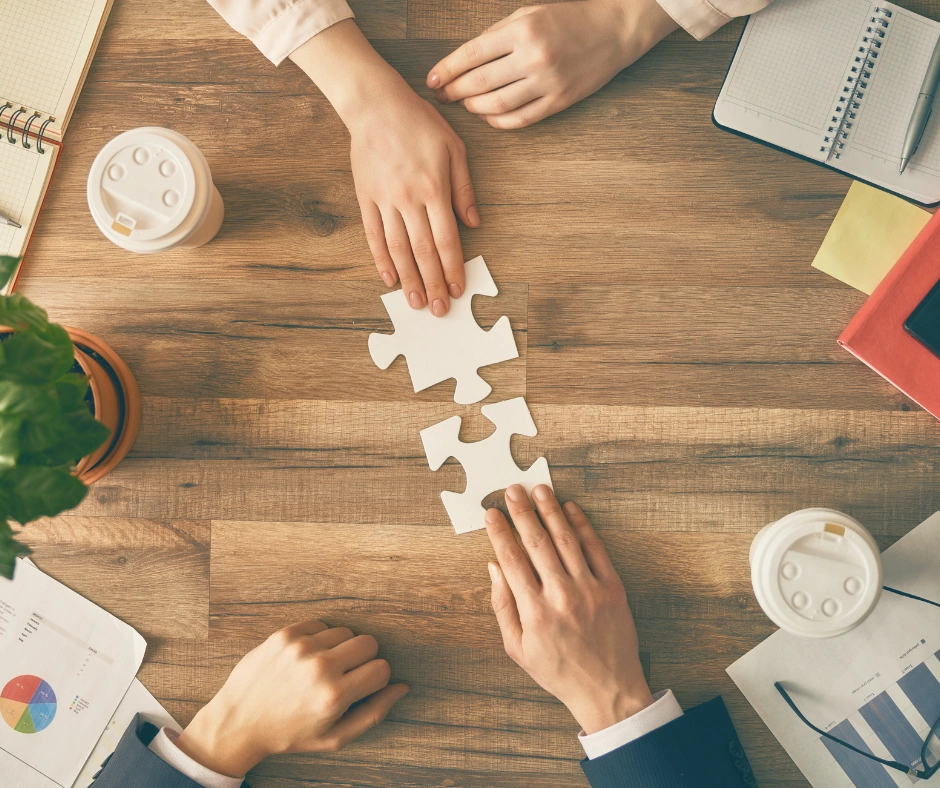 Gezinsleden leggen puzzelstukken tijdens therapie systeemgesprek aan tafel in behandelruimte